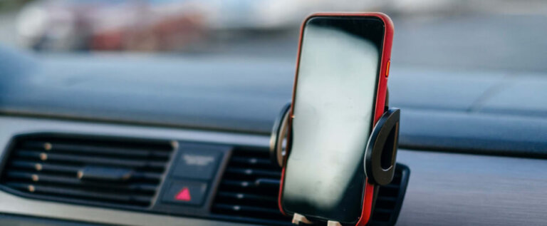 Mobile phone in handsfree car stand on dash